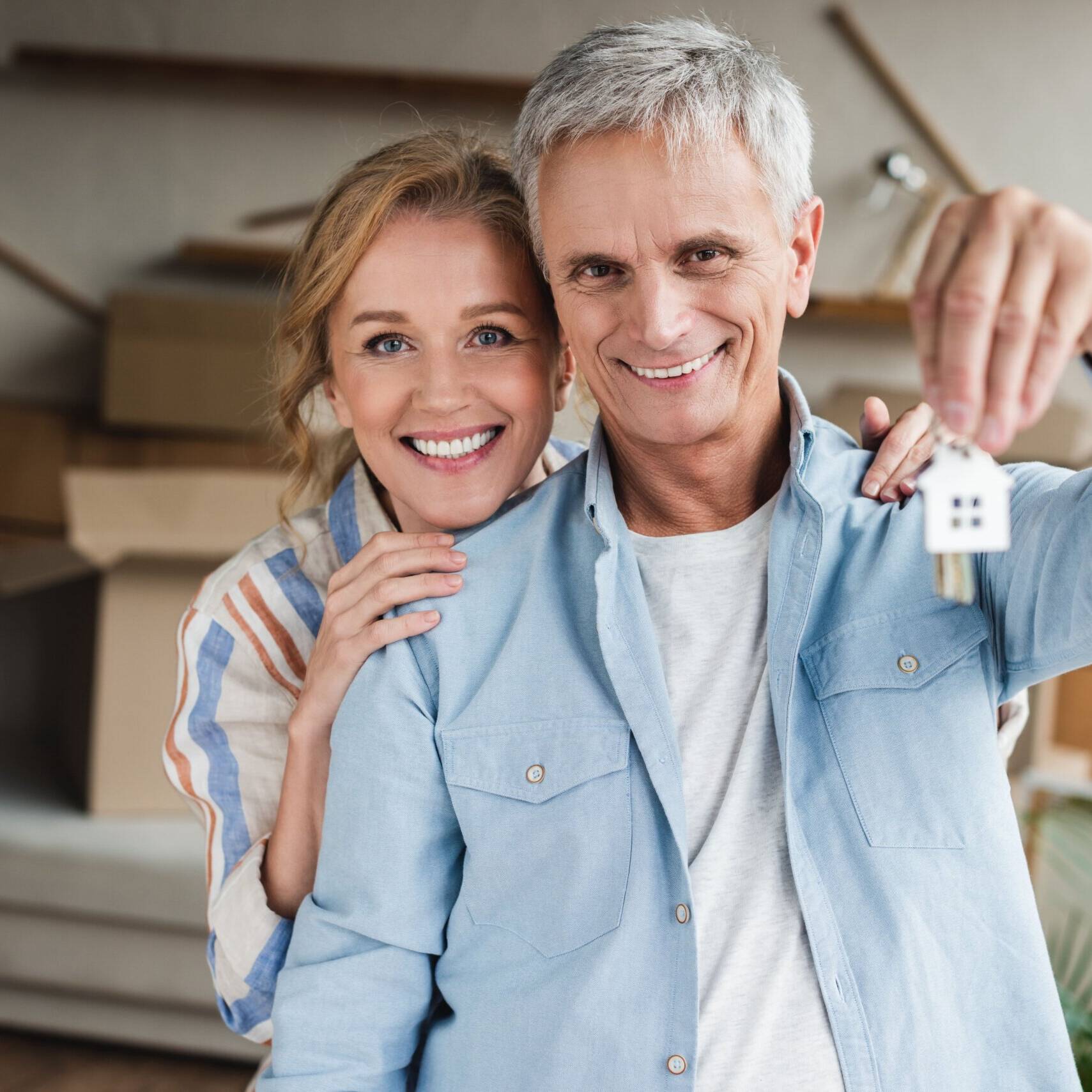 Ehepaar hält nach dem Immobilienkauf den Schlüssel in der Hand